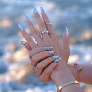A close up of a hand wearing Vectorium Long Press On Nails, handmade by Fasunidy